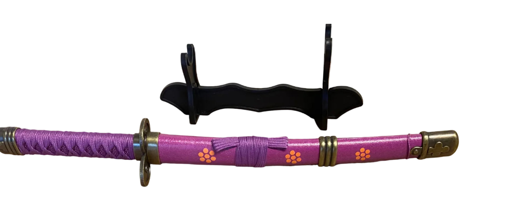 Purple sword with decorative handle on a cardboard surface
