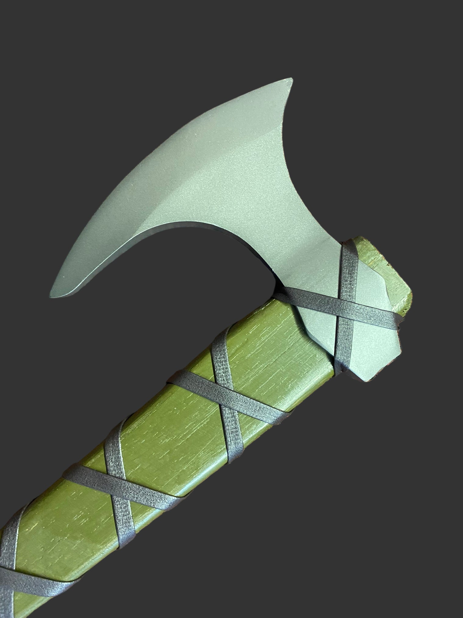 Green axe with a wooden handle on a brown textured surface