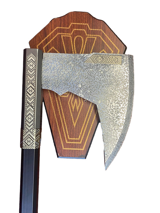Decorative axe with wooden handle and metallic head on a textured surface