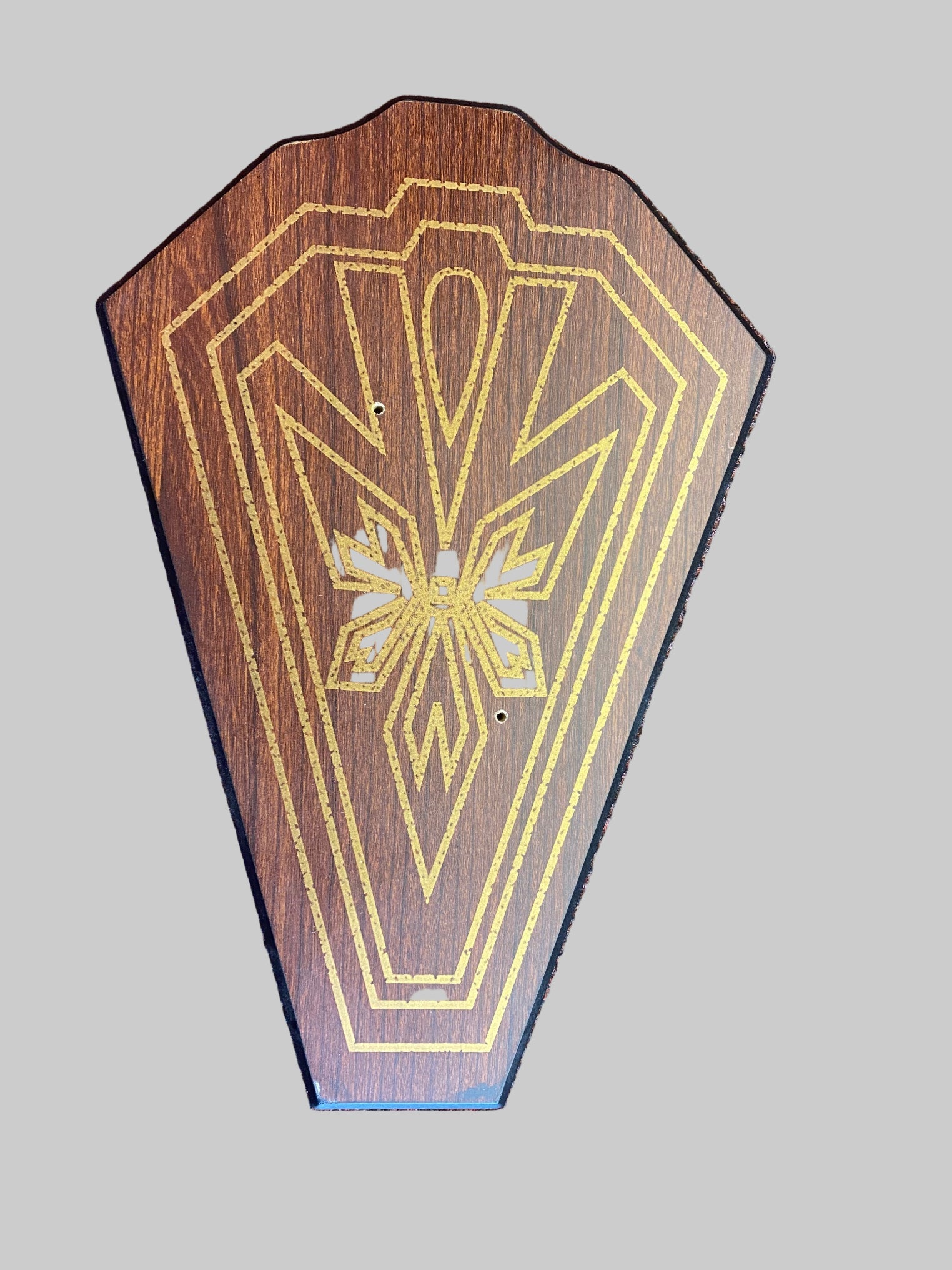 Wooden plaque with geometric design on a textured surface
