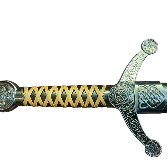Decorative sword handle with intricate designs on a textured surface