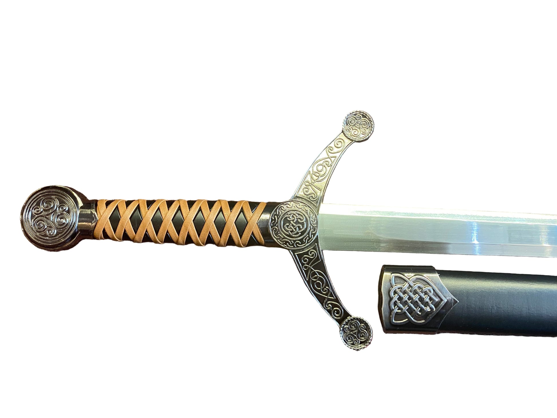 Decorative sword with ornate handle on a textured brown surface