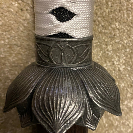 Decorative sword hilt with intricate design on a textured surface
