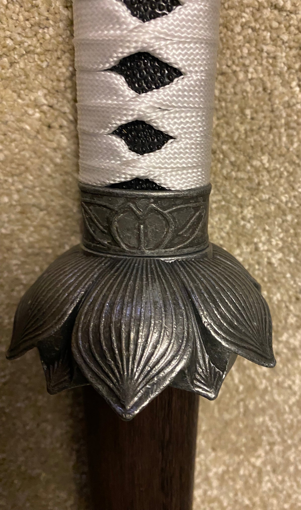 Decorative sword hilt with intricate design on a textured surface