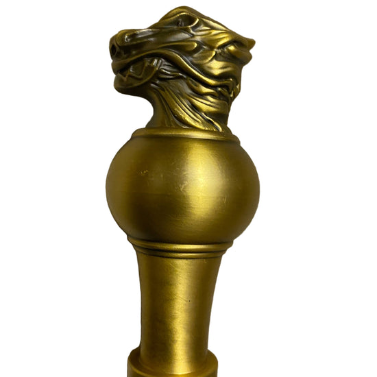 Decorative gold finial on a textured surface