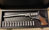 Decorative revolver with wooden grip and metal components in a display case.