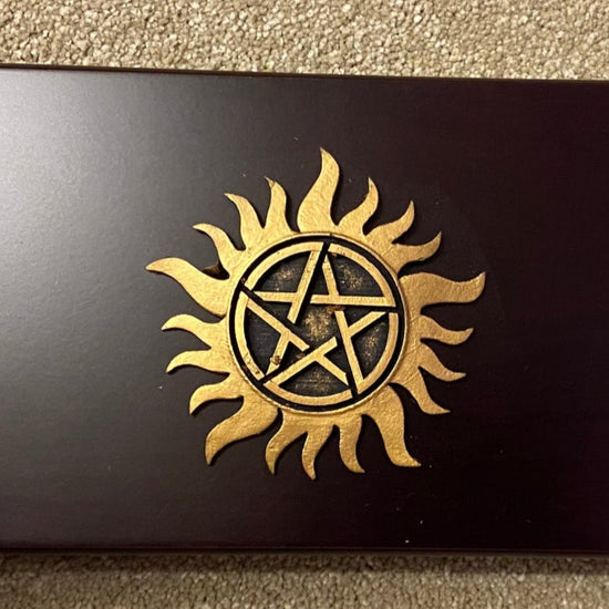 Black box with gold symbol on a beige carpet
