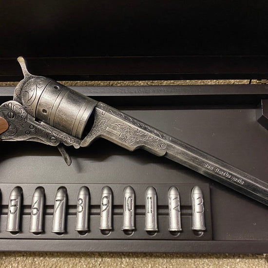 Vintage revolver and bullets in a wooden gun case.