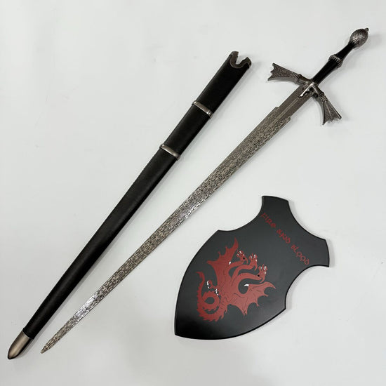 Decorative sword with sheath and shield featuring a dragon design on a white background