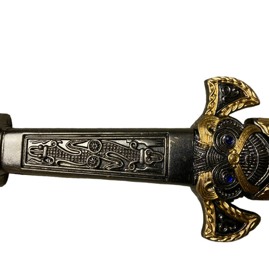 Decorative sword handle with intricate designs on a white background