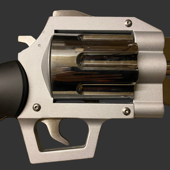 Close-up of a silver revolver on a beige background