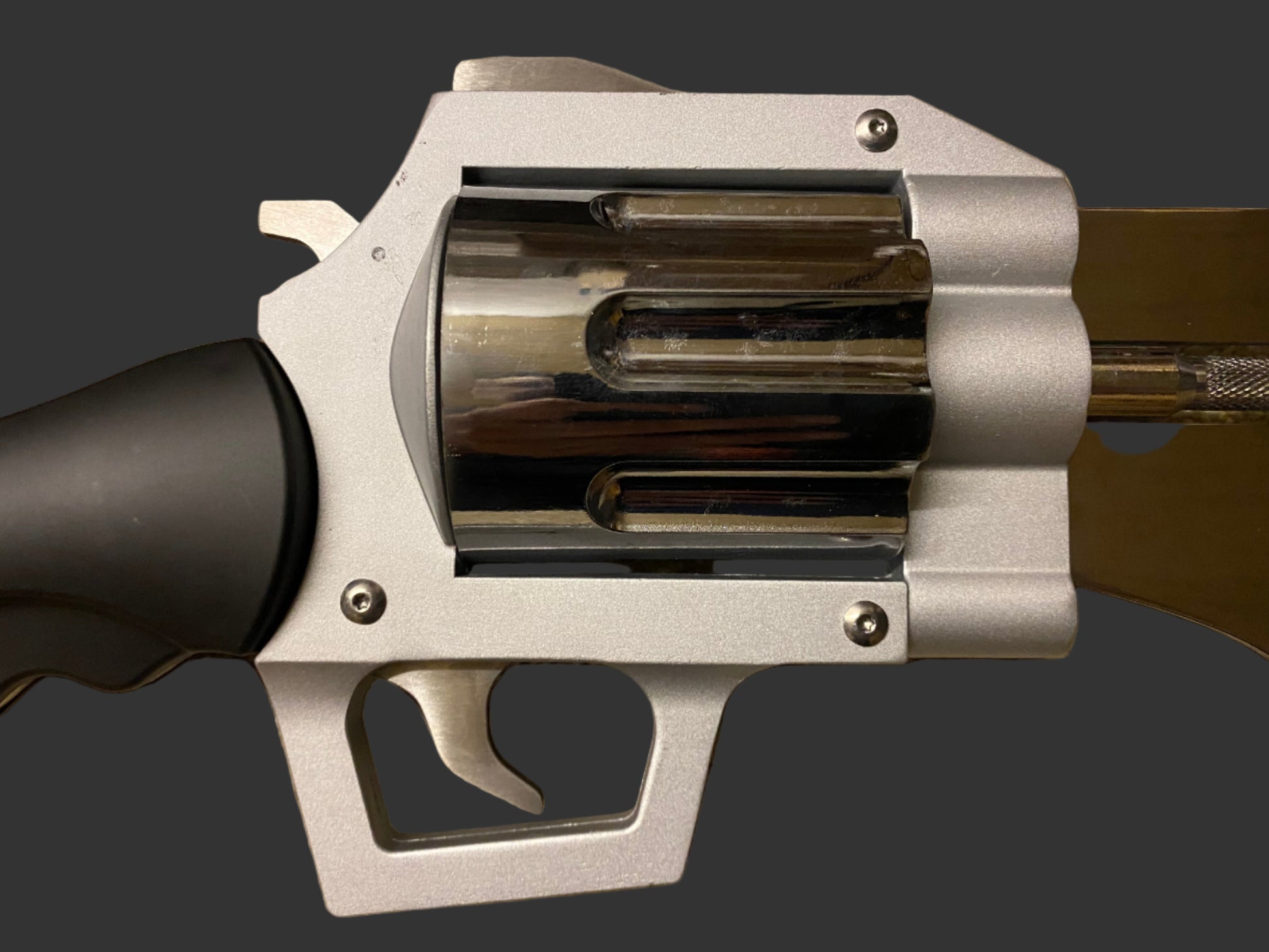 Close-up of a silver revolver on a beige background