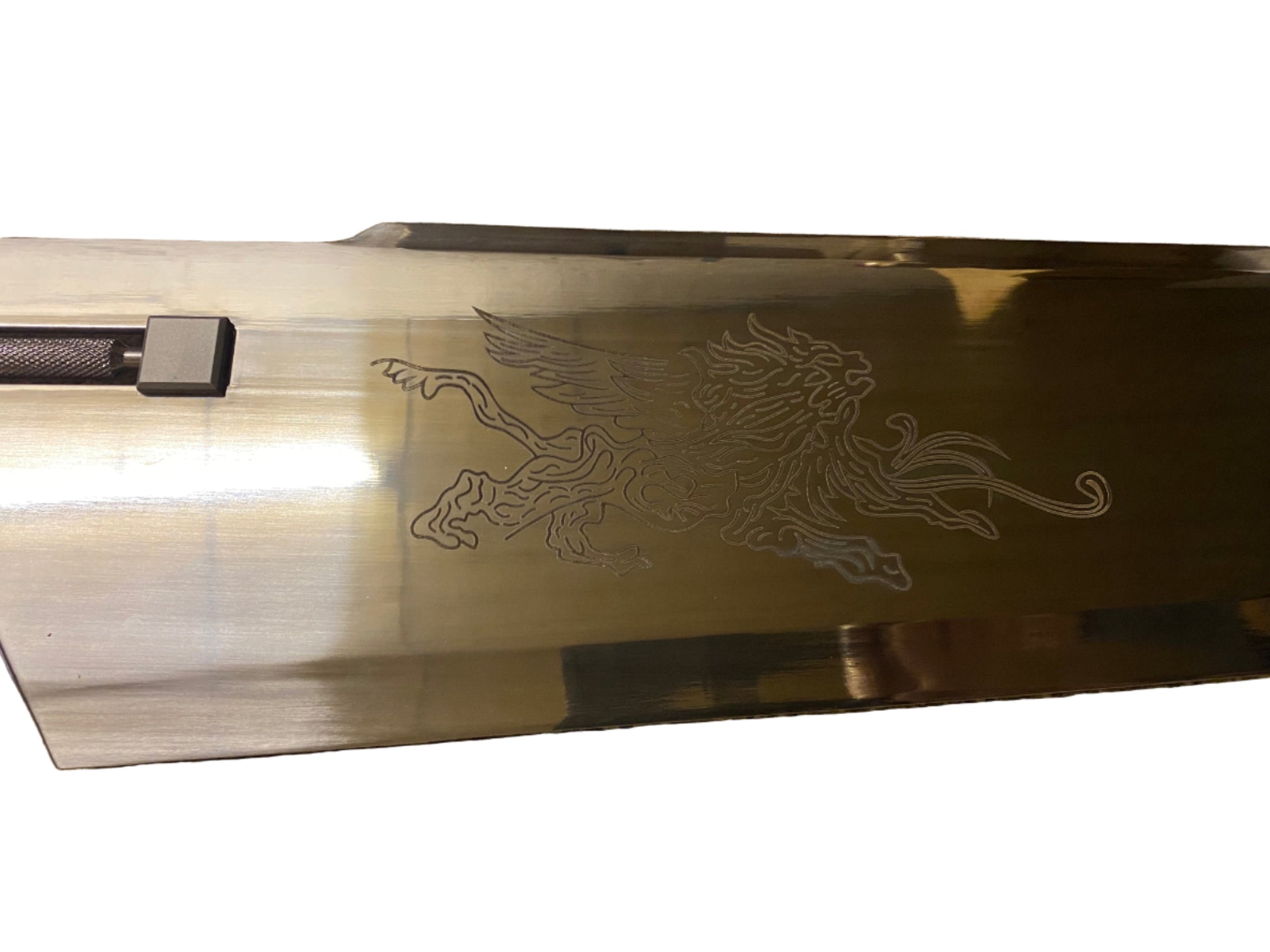 Gold-colored object with a engraved design on a white background