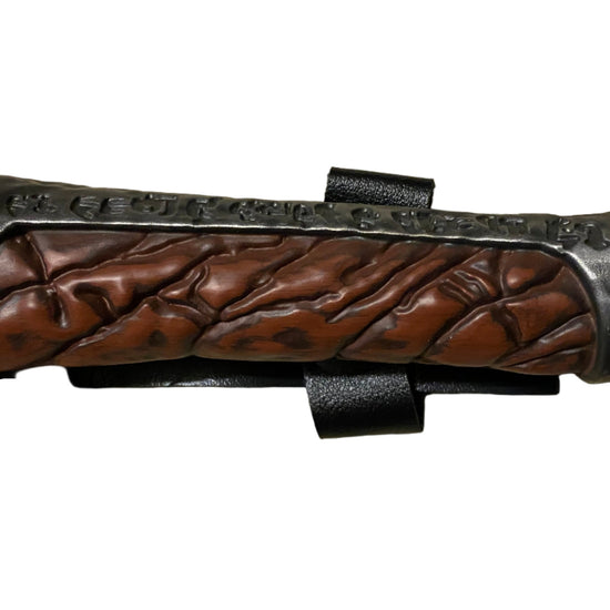 Wooden handle of a knife with metal accents on a white background