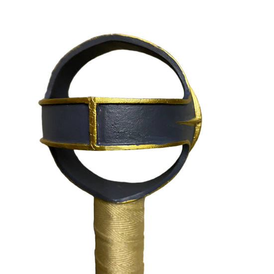 Sword hilt with black and gold design on a white background