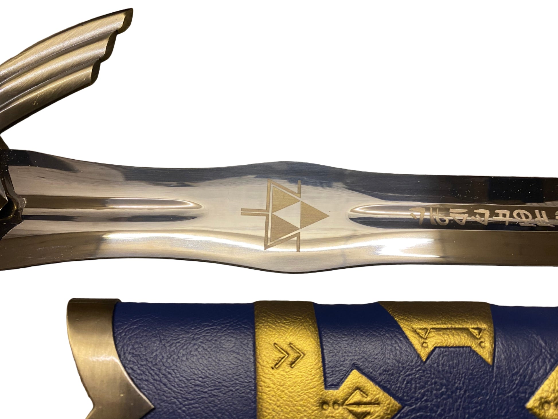 Close-up of a sword with gold and blue design on a white background
