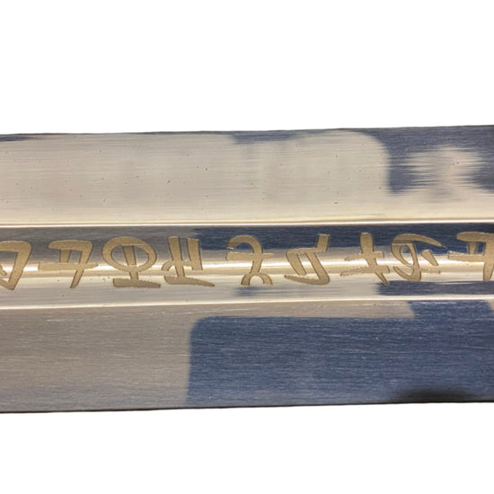Sword blade with engraved text on a white background