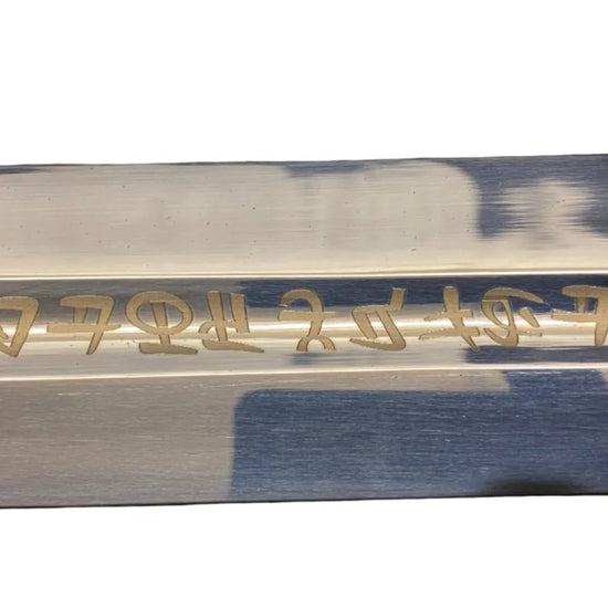 Sword blade with engraved text on a white background