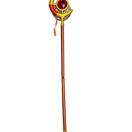 Decorative staff with a red gem and gold accents on a counter.