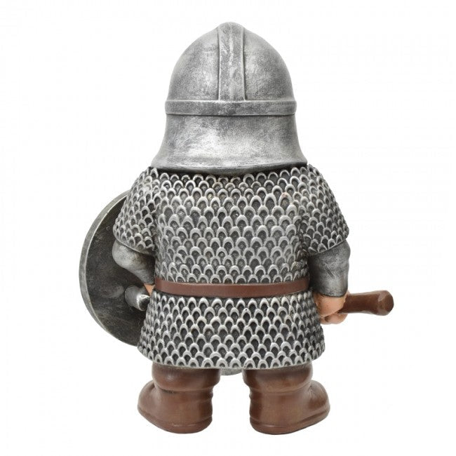 A medieval knight figurine shown from the back, wearing a silver chainmail patterned tunic, a silver helmet, brown boots, and holding a round shield and a wooden mace. The figurine is photographed on a clean white background with a small 'The Knight Shop' logo in the bottom right corner.