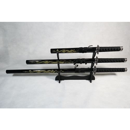 A set of three decorative dragon-themed Samurai swords with black handles and sheaths, displayed on a wooden stand against a white background.