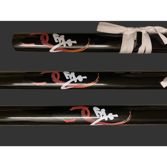 Black baseball bat with red and white designs on a gray background