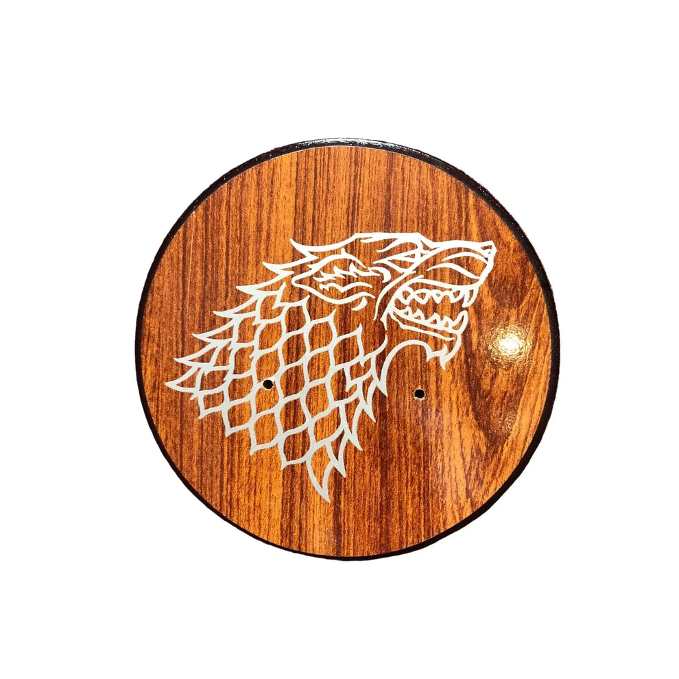 Wooden circular plaque with a white wolf design on a white background
