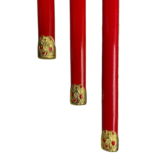 Three red objects with gold decorative elements on a white background