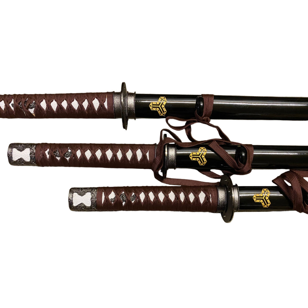 Three samurai swords with brown sheaths on a white background