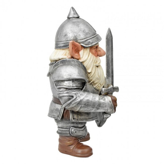 A small gnome figurine dressed as an armored knight, holding a sword, shown against a plain white background. The figurine has silver-gray armor and helmet, a cream-colored beard, brown boots, and pointed ears.