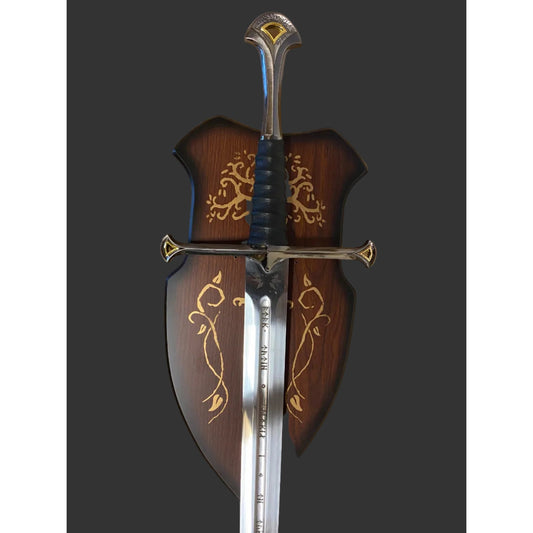 A decorative medieval-style sword with a polished silver blade, black wrapped hilt, and ornate gold detailing, shown alongside a matching dark brown wooden scabbard decorated with gold floral patterns.