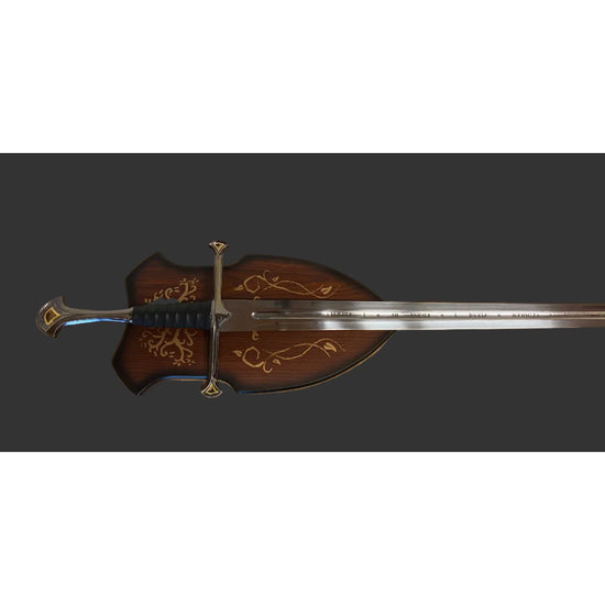 A decorative medieval-style sword with a dark brown wooden scabbard featuring gold floral engravings, a silver blade, and a gold crossguard, shown against a solid dark gray background.