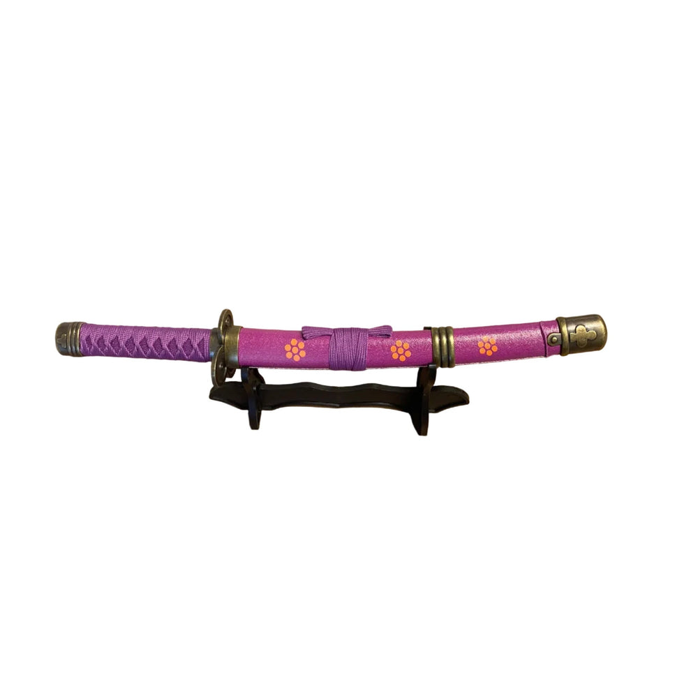 Purple  sword with decorative elements on a stand against a plain background