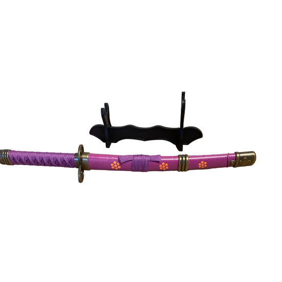 Purple sword with decorative handle on a cardboard surface