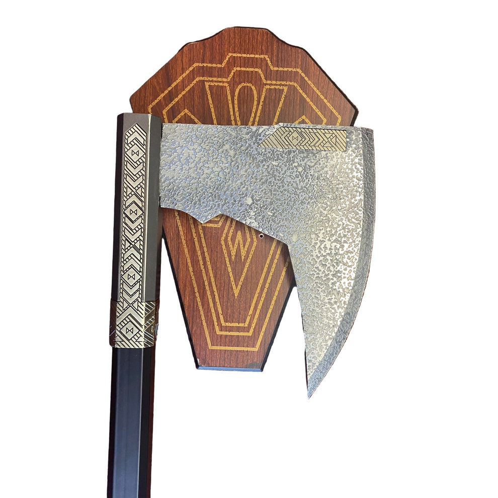 Decorative axe with wooden handle and metallic head on a textured surface
