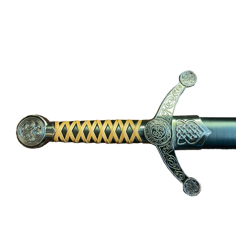 Decorative sword handle with intricate designs on a textured surface