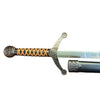 Decorative sword with ornate handle on a textured brown surface
