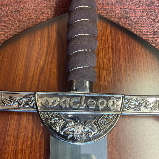 Sword with decorative hilt on a wooden surface