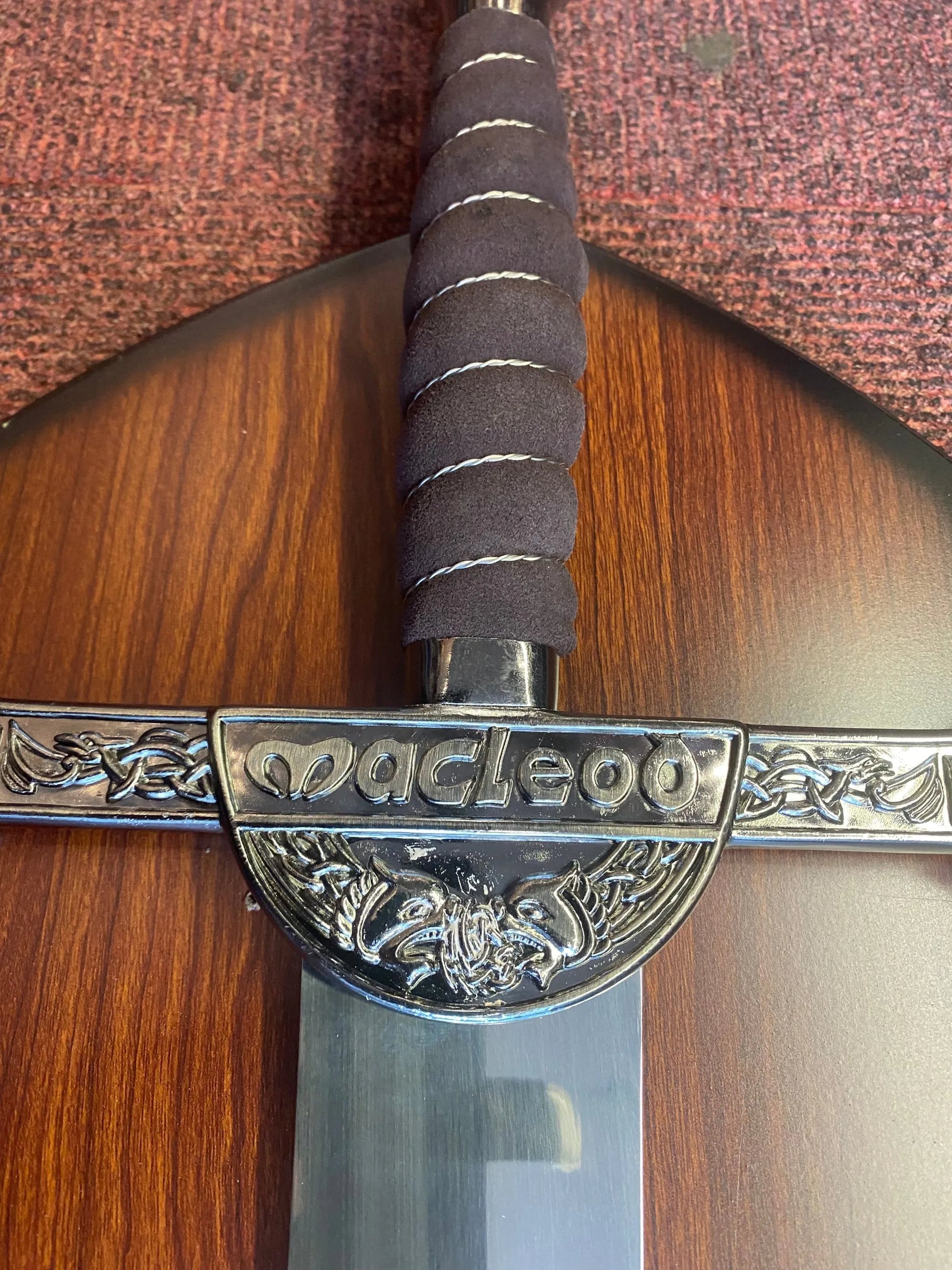 Sword with decorative hilt on a wooden surface