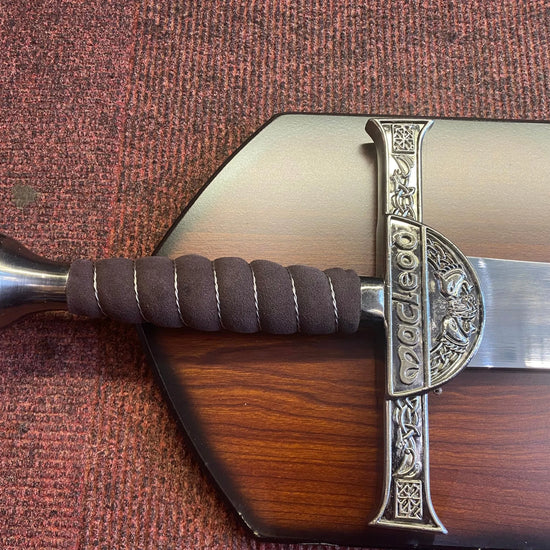 Decorative sword with a wooden sheath on a textured surface
