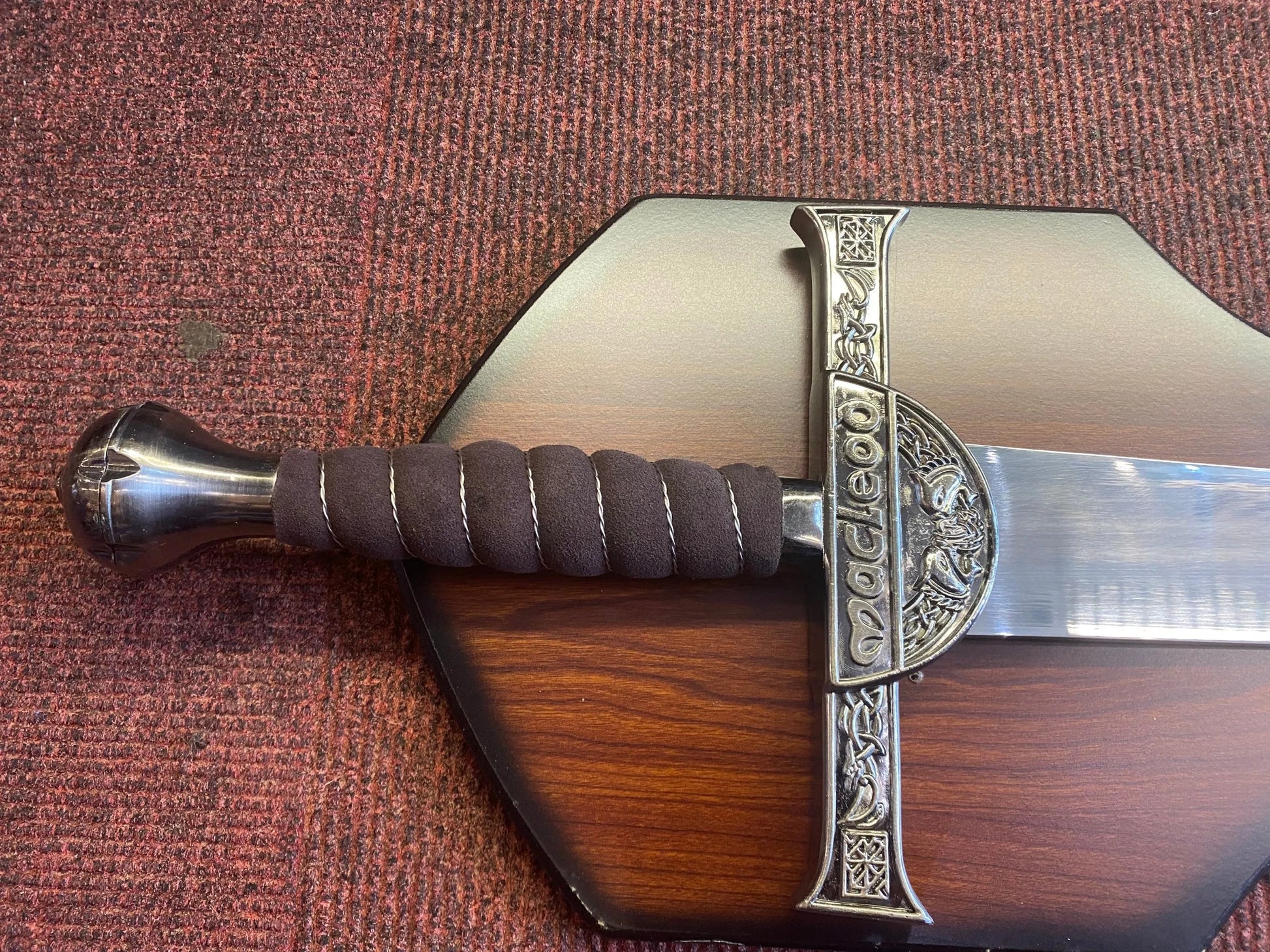 Decorative sword with a wooden sheath on a textured surface