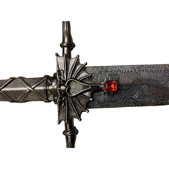 Decorative dagger with intricate design and red gemstone on a white background