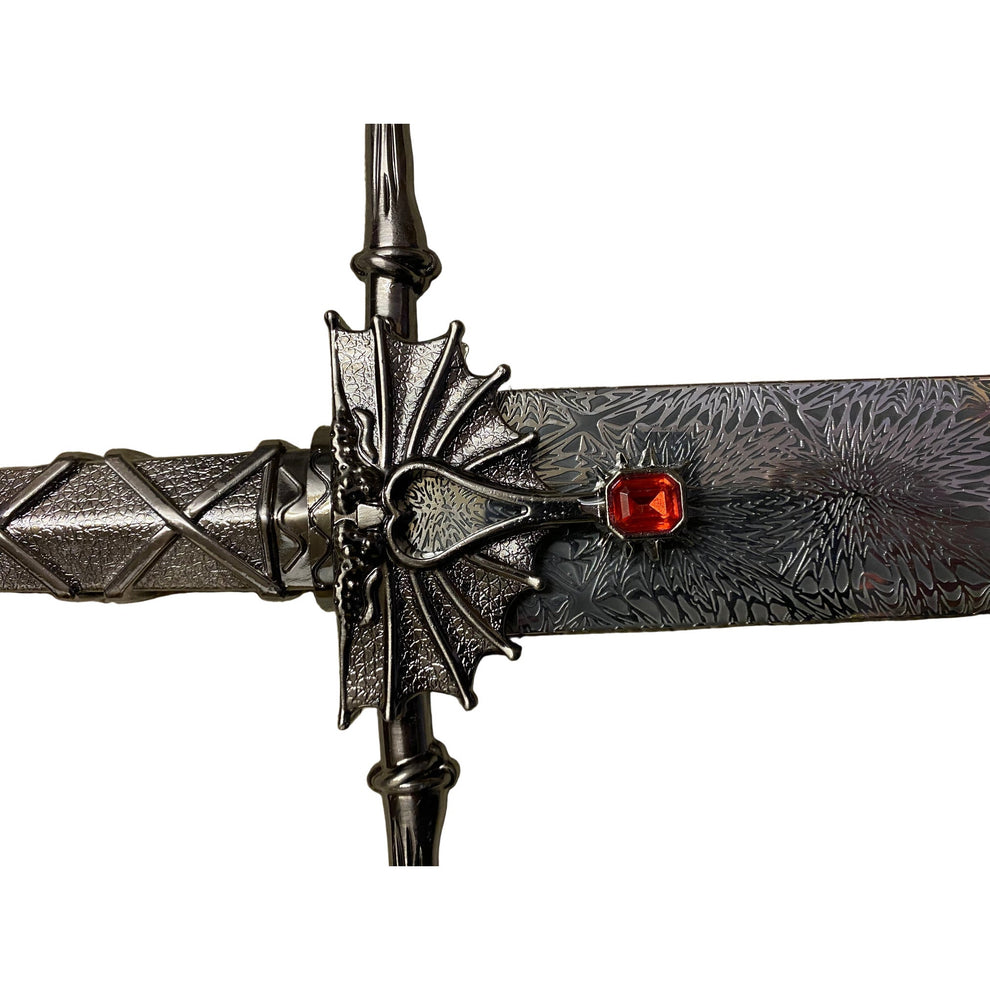 Decorative dagger with intricate design and red gemstone on a white background