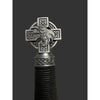 Decorative object with Celtic cross design featuring a bird, on a dark background.