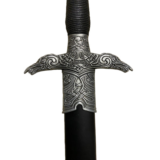 Decorative sword handle with intricate metalwork on a white background