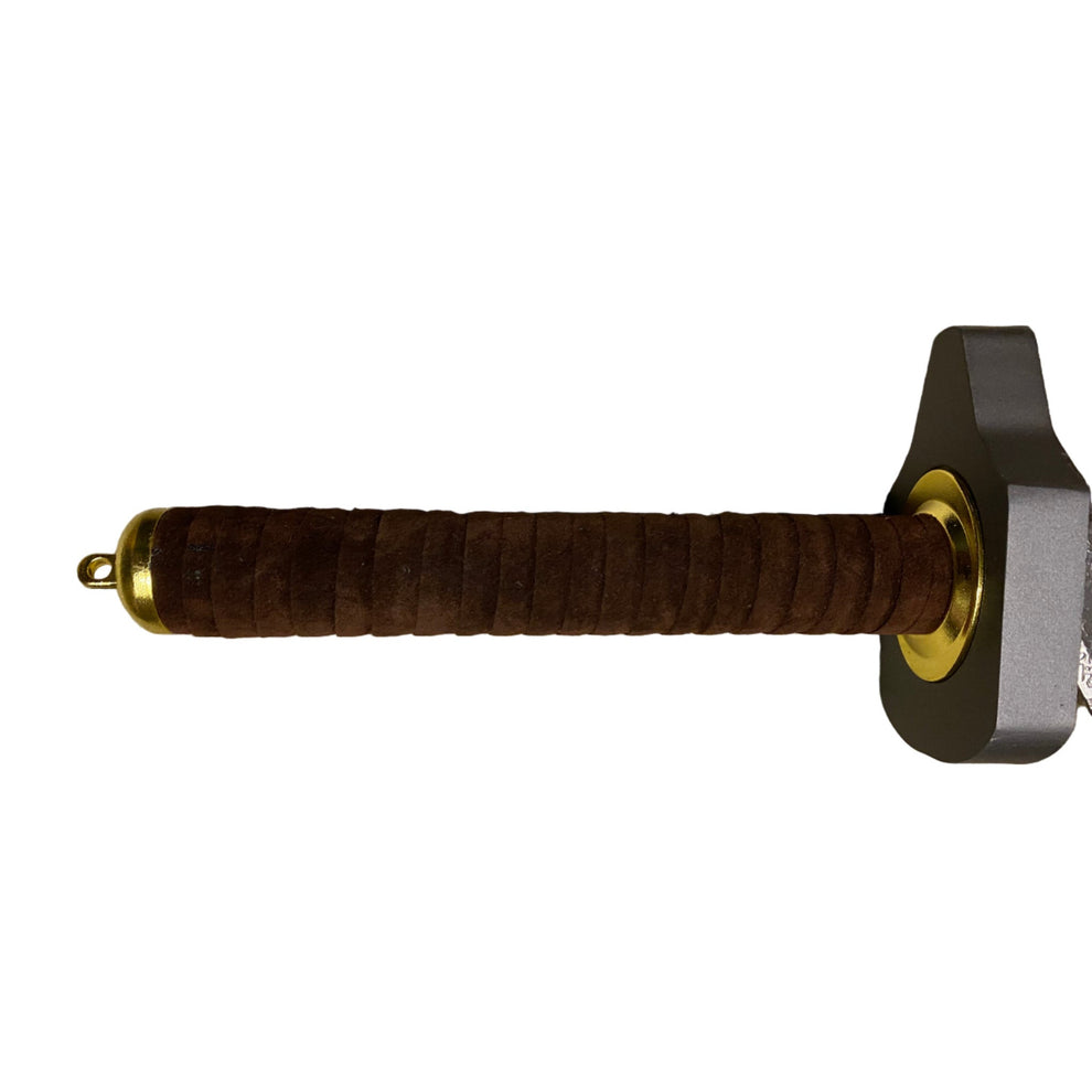 Sword handle with brown grip and gold accents on a beige carpet